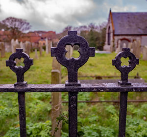 Close-up of metal fence in cemetery