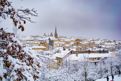 Buildings in city against sky during winter