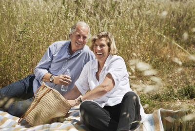 Portrait of happy couple enjoying picnic on grassland