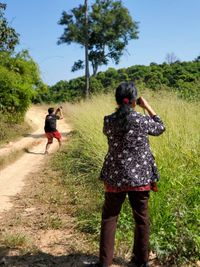 Rear view of man and woman walking on road