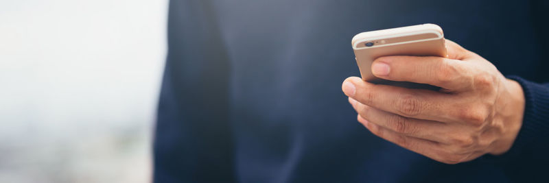 Midsection of man using mobile phone