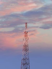 Low angle view of electricity pylon against sky during sunset