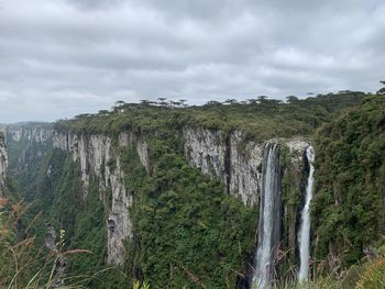 Scenic view of waterfall against sky