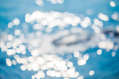 Defocused image of illuminated lights in sea on sunny day