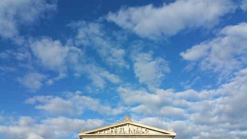 High section of historic building against cloudy sky