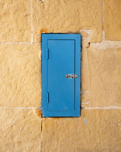 Close-up of blue window on wall of old building