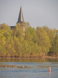 Scenic view of lake by temple against sky