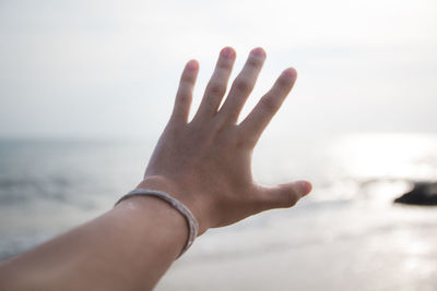 Midsection of person against sea against sky