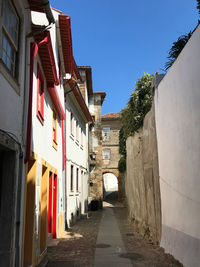 Narrow street amidst buildings against clear sky