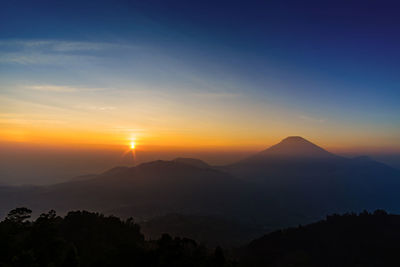 Scenic view of silhouette mountains against sky at sunset