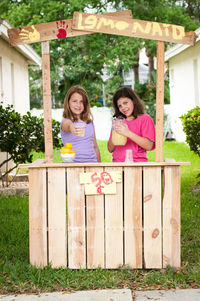 Portrait of a smiling girl standing against fence