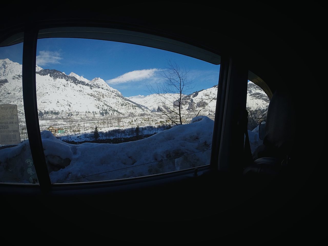 window, snow, cold temperature, winter, vehicle interior, mountain, indoors, glass - material, transparent, transportation, sky, season, landscape, mode of transport, weather, nature, scenics, mountain range, snowcapped mountain, looking through window