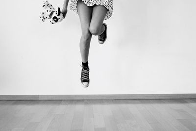 Low section of woman with toy on mid-air at home