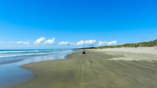 Scenic view of beach against blue sky