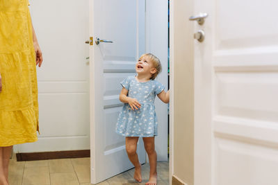 Side view of young woman standing at home