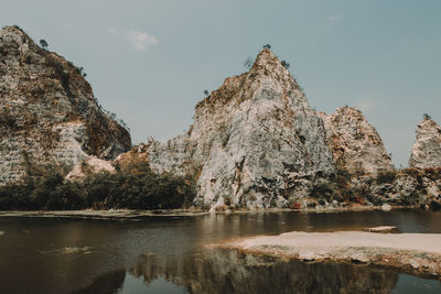 Scenic view of lake by mountains against sky