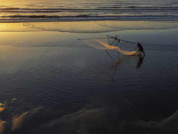 Fisherman working with net at beach