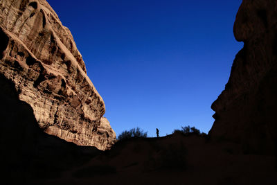 Low angle view of rock formation against clear blue sky