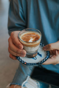 Cropped image of hand holding coffee cup