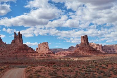 Rock formations on landscape against cloudy sky