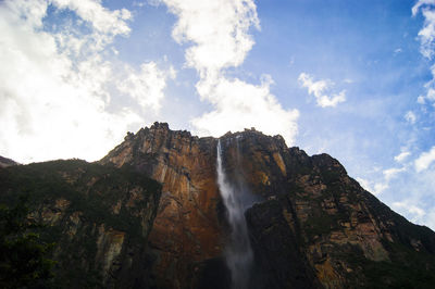 Low angle view of waterfall against sky