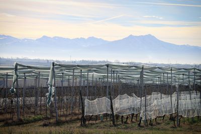 Fence on landscape against mountains and sky