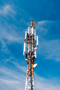 Low angle view of communications tower against blue sky