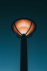 Low angle view of illuminated street light against blue sky