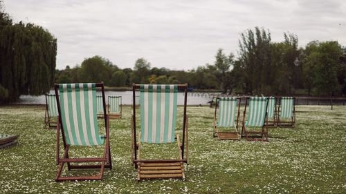 Chairs on field against sky