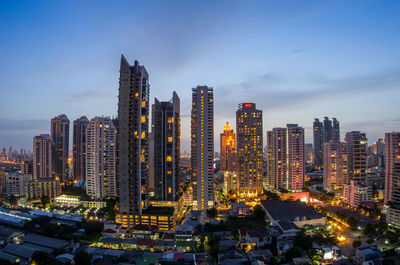 Illuminated buildings in city against sky