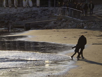 Mother and daughter running at beach