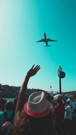 People on airplane against clear blue sky