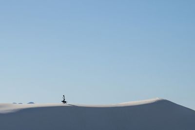 Man on mountain against clear blue sky