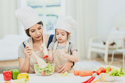 Midsection of woman having food in kitchen