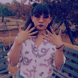Portrait of young woman wearing sunglasses standing outdoors