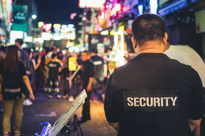 Rear view of people on street at night