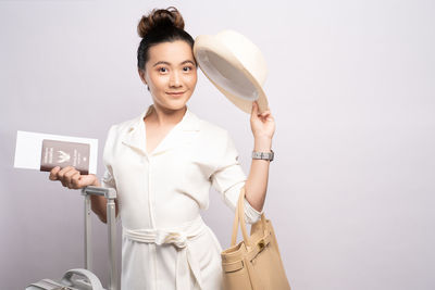 Portrait of smiling woman standing against white background