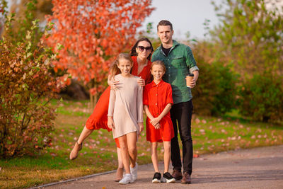 Full length portrait of father and daughter standing on wall