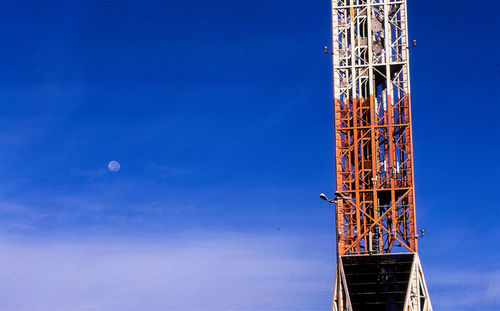 Low angle view of crane against clear blue sky