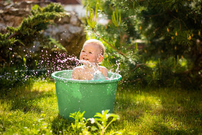 Portrait of a boy against plants in yard