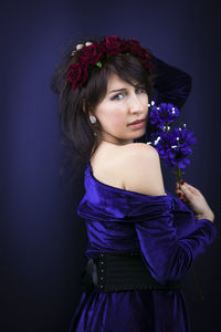 Portrait of a beautiful young woman against blue background