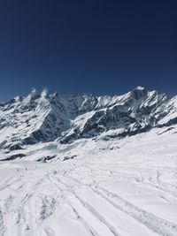 Scenic view of snowcapped mountains against clear blue sky