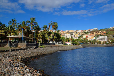 River with built structures against blue sky