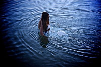 High angle vie w of young woman wearing white dress while standing in lake