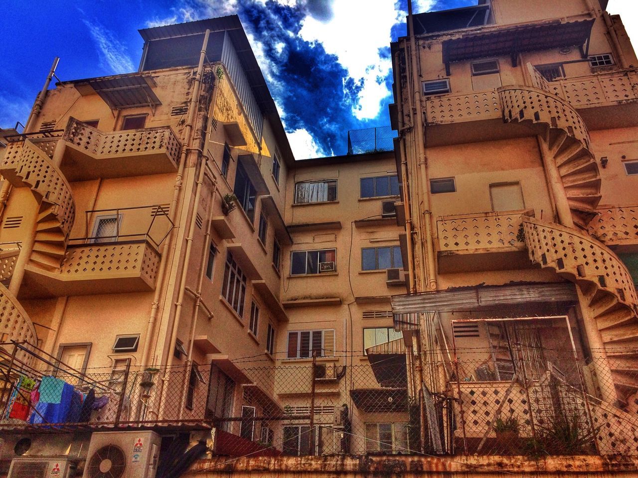 building exterior, architecture, built structure, low angle view, blue, window, sky, building, residential building, residential structure, city, sunlight, outdoors, day, old, house, facade, no people, cloud, old town