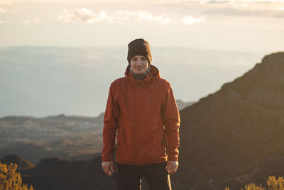 Traveller with smile enjoys view from pico ruivo, highest mountain on portuguese island of madeira