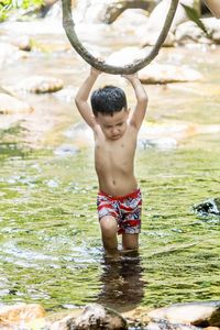 Full length of shirtless boy in water