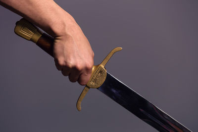 Close-up of hand holding crane against white background