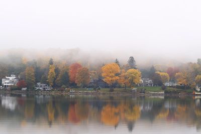 Scenic view of lake by trees against sky during autumn