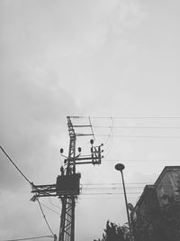 Low angle view of silhouette cranes against sky